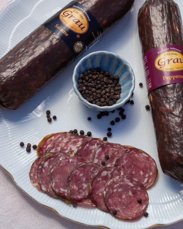 Salame de Cecinas Grau entero y laminado, junto a una pieza de pepperoni